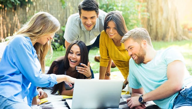 Interns group on picnic with a laptop