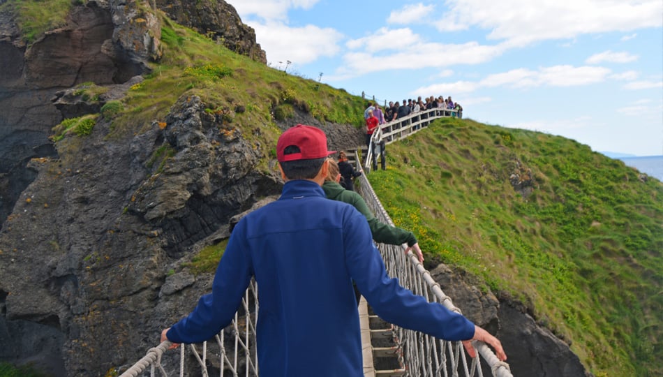 Man walking across Carrick-a-rede-rope bridge