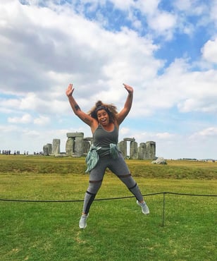 London Marketing intern Mariah jumping in front of Stonehedge