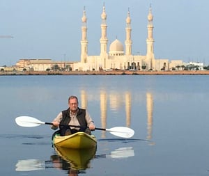 Man on a kayak in front of castle