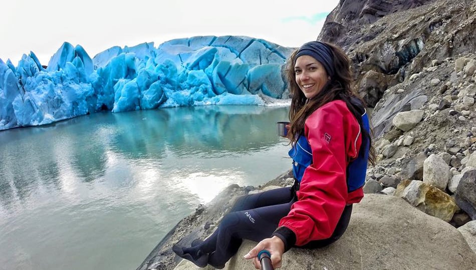 Woman sitting on a rock by a glacier