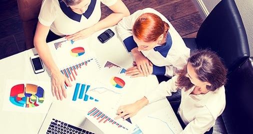 Marketers gather around a table to talk about exciting projects 