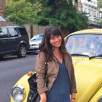 Marisa standing in front of yellow VW in the streets of London