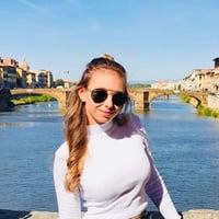 Grace C. standing on a bridge over blue water in Florence