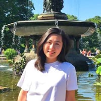 Ashley F. sitting in front of a grand fountain.