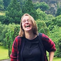 Cheyenne H. laughing in a lush green forest