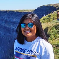 Christine B. smiling at the Cliffs of Moher.